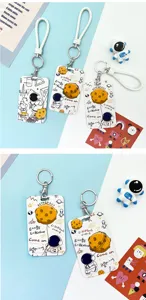 Detailed view of cute astronaut cartoon ID card holders with lanyards and space theme graphics.