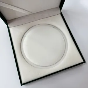 Caja de joyería de terciopelo verde oscuro de lujo, interior blanco elegante para anillos y collares.