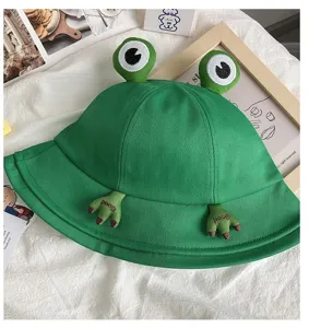 Close-up detail of the cute green frog bucket hat with 3D eyes and embroidered frog hands.