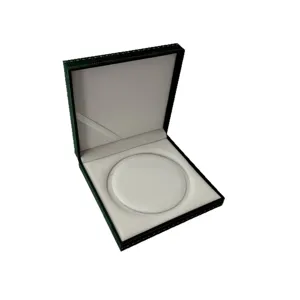 Joyero de terciopelo verde oscuro con borde dorado, estuche prémium para anillos y collares.