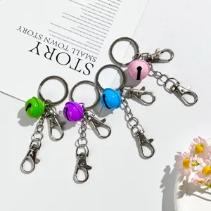 Candy color metal bell keychains with double dog clips and split rings for bags and keys.
