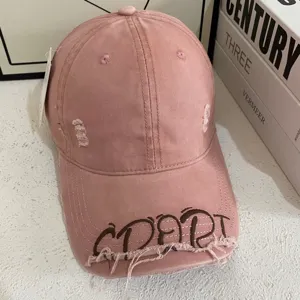 Amerikanische Retro-Baseballkappe in Rosa mit gestickten Graffiti-Buchstaben und gebogenem Schirm.