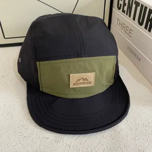 Casquette 5 panneaux unisexe en tissu séchage rapide, visière courte souple et patch aventure.