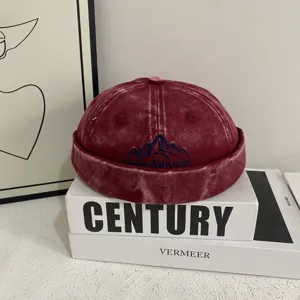 Retro washed denim dockers hat with mountain embroidery, casual streetwear skull cap detail.