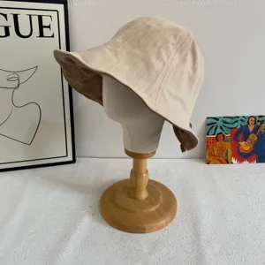 Gros plan detail d'un chapeau seau beige minimaliste sur un mannequin en bois, protection.