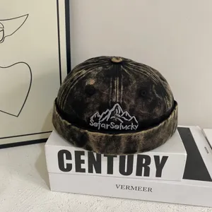Detailed shot of retro denim watch cap with mountain embroidery, street style casual docker hat.