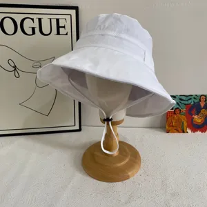 Cappello da sole estivo bianco in tessuto ad asciugatura rapida con sottogola regolabile.