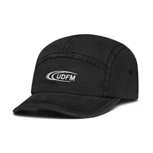 Close-up detail of the black washed cotton 5-panel short brim baseball cap with UDFM embroidery.