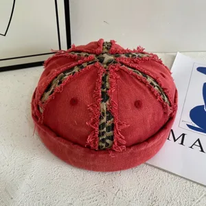 Close-up detail of retro washed red denim docker cap featuring leopard print cross stripes.