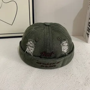 Vintage distressed denim docker cap with ripped details and Trust embroidery for streetwear style.