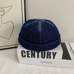 Vista dettagliata del berretto docker in denim lavato blu scuro, cappello streetwear senza tesa.