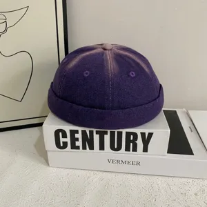 Primo piano del berretto docker in denim lavato viola rétro con trama e cuciture uniche.