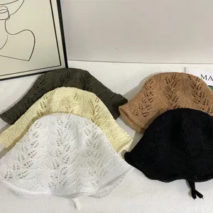 Close-up detail view of hollow knit bucket hats in assorted colors, breathable and stylish.