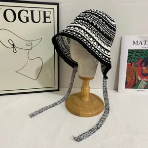 Handmade crocheted hollow knit bucket hat with long straps, detailed view of texture.