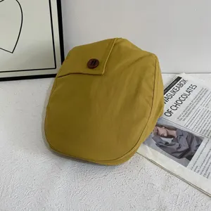 Retro gelbe Schiebermütze mit Holzknopf Detail, stilvolles Herbst Modeaccessoire Nahaufnahme