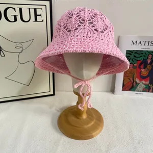 Pink crochet bucket hat detail view, handmade hollow knitted summer beach sun hat.