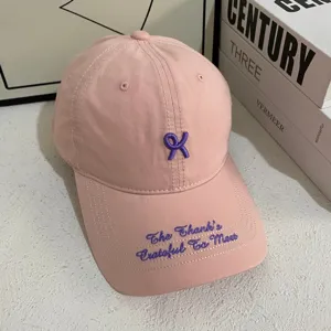 Roze honkbalpet met paarse borduursel, katoenen stof, stijlvol casual dagelijks kledingdetail.