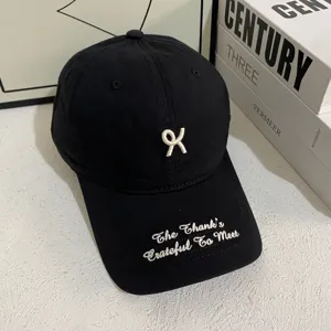 Zwarte baseballpet met witte borduursel en minimalistisch design voor dames en heren.