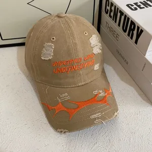 Gorra de béisbol vintage desgastada con bordado naranja y diseño streetwear moderno.