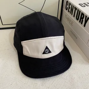 Schwarz-weiße 5-Panel-Camp-Cap mit Farbblock-Design und Detailansicht für Streetwear.