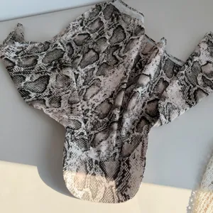 Snakeskin print detail view of the trendy spring summer headscarf cap showing wild pattern.