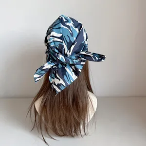 Vista detallada de pañuelo camuflaje azul, nudo ajustable, estilo streetwear hip-hop.