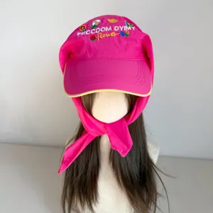 Detailed view of the sweet pink baseball cap with floral embroidery and integrated long scarf tie.