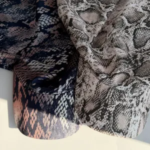 Close-up detail of trendy snakeskin print headscarf cap, showing soft fabric texture.