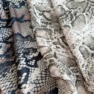 Snake print fabric detail shot showing soft texture and wild animal pattern design for chic apparel.