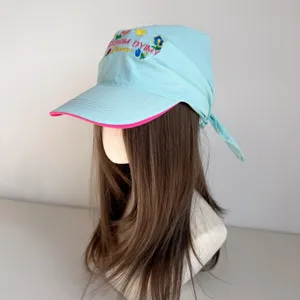 Detailed view of the light blue floral embroidered baseball cap with unique headscarf design.