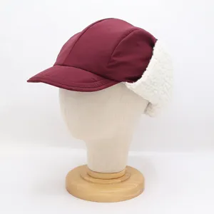 Vue détaillée de casquette trappeur bec de canard coupe-vent d'hiver, tissu bordeaux et polaire.