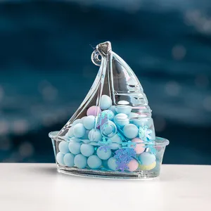 Detail du contenant transparent en forme de voilier avec perles colorees et pendentif ocean.
