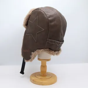Détail du bonnet aviateur en cuir marron avec surpiqûre d'étoile et doublure en fausse fourrure.