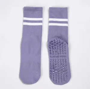 Non-slip yoga socks detail view featuring purple fabric, white stripes, and grip dots.