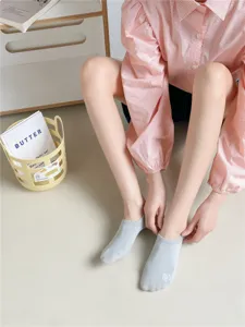 Close-up detail of women's low-cut invisible socks in grey cotton, showing fine toe stitching.