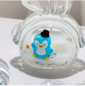 Gros plan detail de porte-cles acrylique sable mouvant d'huile de pingouin mignon flottant.