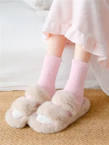Nahaufnahme von niedlichen Plüsch-Tierpfoten-Flauschsocken, weiche und gemütliche Heimkleidung.