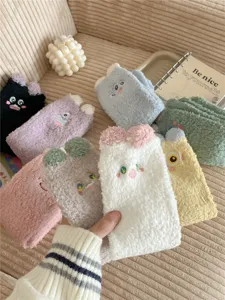 Close-up detail of cute cartoon embroidered thick coral fleece floor socks, cozy and warm.