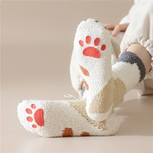 Gros plan de chaussettes d'hiver moelleuses en polaire corail avec jolies pattes de chat.