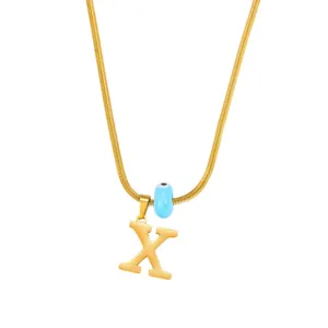 Gold snake chain necklace featuring an evil eye bead and letter X pendant for women.