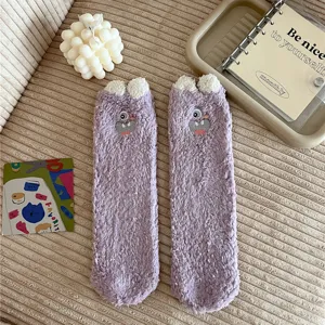 Detail view of plush fuzzy cute cartoon monster purple long cozy floor socks for winter.