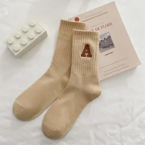 Calzini beige al polpaccio in cotone con elegante lettera A ricamata, tessuto morbido.