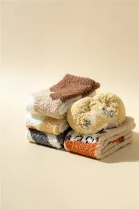 Vue de detail de chaussettes d'hiver en polaire corail moelleuse empilees pour femmes.
