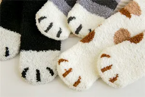 Gros plan detaille de chaussettes d'interieur douillettes en polaire douce motif patte de chat.