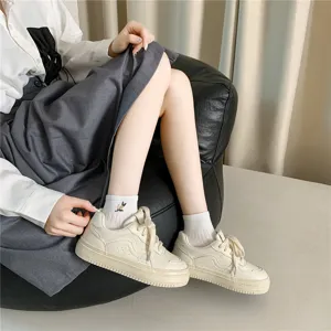 Κομψή λεπτομέρεια από casual γυναικεία sneakers και κεντημένες κάλτσες για στυλ.
