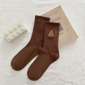 Calze marroni a metà altezza in maglia con lettera A ricamata, stile vintage casual.