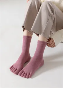 Gros plan détaillé des chaussettes à orteils roses en coton avec texture côtelée.