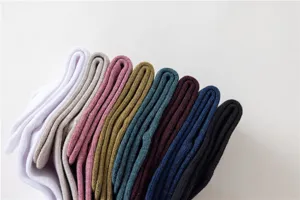Gros plan détaillé de chaussettes mi-tubes pour femmes multicolores soigneusement empilées.