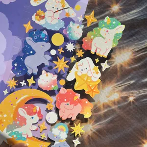 Nahaufnahme von holografischen Einhorn- und Sternen-Aufklebern, ideal für Tagebuch.