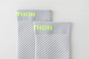 Chaussettes de compression sport grises avec motif tricoté diagonal et revers jaune fluo.